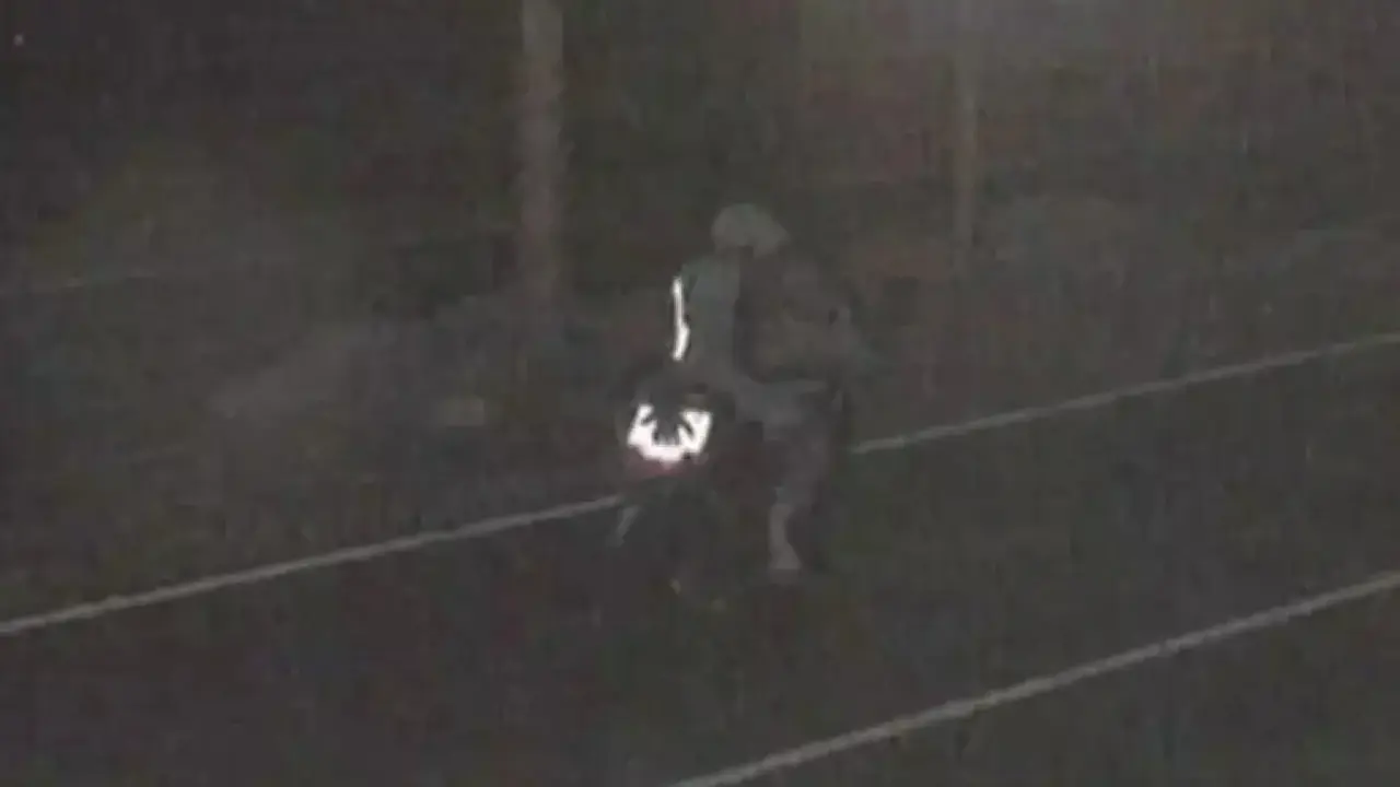 El motorista tapando la matrícula con la mano